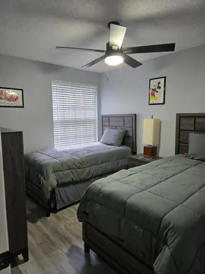 a bedroom with two beds and a ceiling fan at Great condo getaway! in Kissimmee