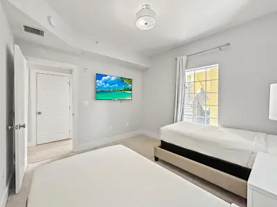 a white bedroom with a bed and a window at Modern & Spacious 3 Bedroom Retreat! in Orlando