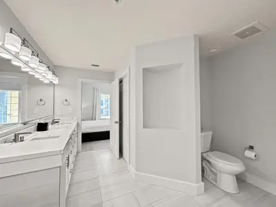 a white bathroom with a toilet and a sink at Modern & Spacious 3 Bedroom Retreat! in Orlando
