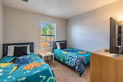 a bedroom with two beds and a tv and a desk at Private Hot Tub near Disney Parks in Kissimmee