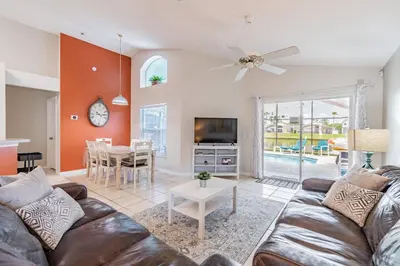 a living room with a couch and a tv and a table at Private Heated Pool near Disney in Kissimmee