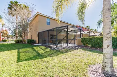 a house with glass windows and a palm tree at 15min to Disney · Modern Home Hot Tub in Kissimmee