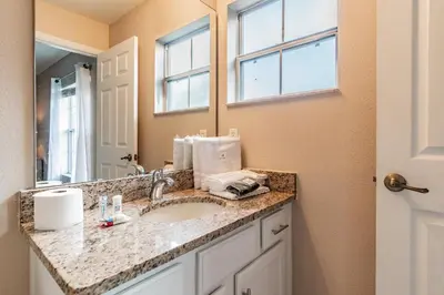 a bathroom with a sink and a mirror at Family Home Near Disney – Modern Bright in Kissimmee