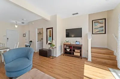 a living room with a blue chair and a television at Family Villa w Pool · 20min Disney in Kissimmee