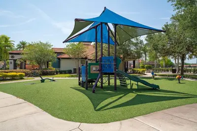 a playground with a swing set and an umbrella at Family Villa w Pool · 20min Disney in Kissimmee