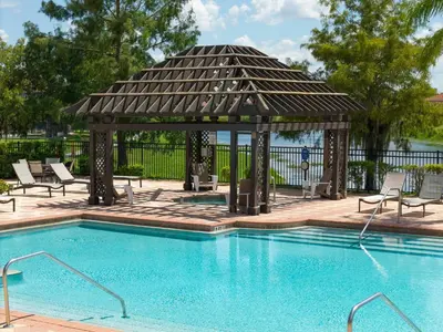 a pool with a gazebo next to a swimming pool at Family Villa w Pool · 20min Disney in Kissimmee