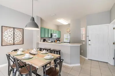 a kitchen and dining room with a table and chairs at Family Townhome Near Disney w Heated Pool in Kissimmee