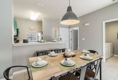 a kitchen and dining room with a table and chairs at Family Townhome Near Disney w Heated Pool in Kissimmee
