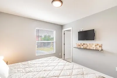 a bedroom with a bed and a flat screen tv at Family Townhome Near Disney w Heated Pool in Kissimmee
