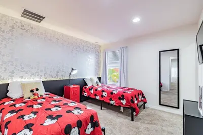 a bedroom with two beds and a red bedspread with cows on it at 3BR Townhome Near Disney Free Jacuzzi in Kissimmee