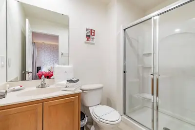 a bathroom with a toilet and a glass shower at 3BR Townhome Near Disney Free Jacuzzi in Kissimmee