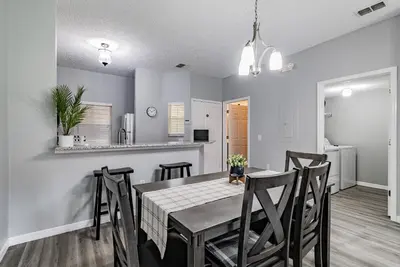 a dining room and kitchen with a table and chairs at Cozy 3BR Townhome Near Disney in Kissimmee in Kissimmee