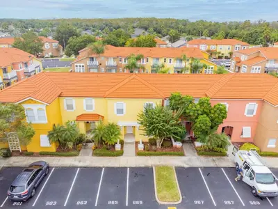 an aerial view of a house with cars parked in a parking lot at Cozy 3BR Townhome Near Disney in Kissimmee in Kissimmee