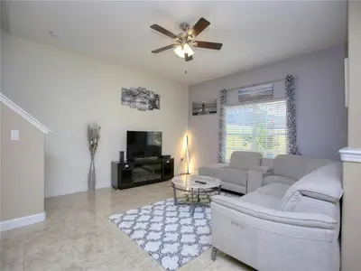 a living room with a couch and a ceiling fan at Cozy 3BR Villa 15min from Disney Heated Pool in Kissimmee