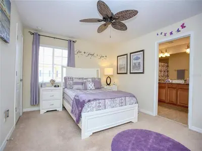 a bedroom with a bed and a ceiling fan at Cozy 3BR Villa 15min from Disney Heated Pool in Kissimmee