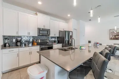 a kitchen with white cabinets and a counter top at Disney 15min - Private Pool BBQ in Kissimmee