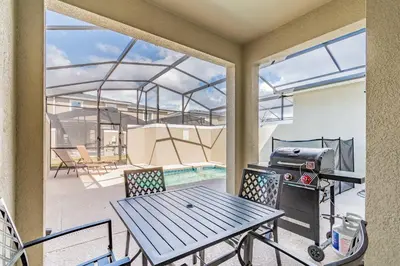 a patio with a picnic table and a grill at Disney 15min - Private Pool BBQ in Kissimmee