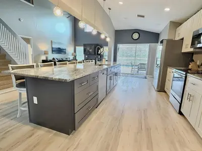a large kitchen with a large island in the middle at Lake Berkley Getaway – 5BR Private Pool in Kissimmee