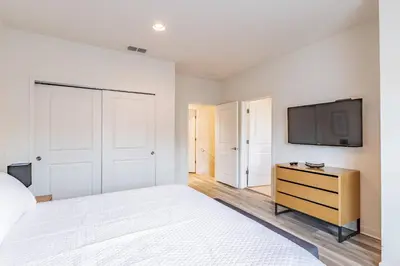 a bedroom with a bed and a tv on a wall at 2BR Villa Near Disney Resort Amenities in Kissimmee
