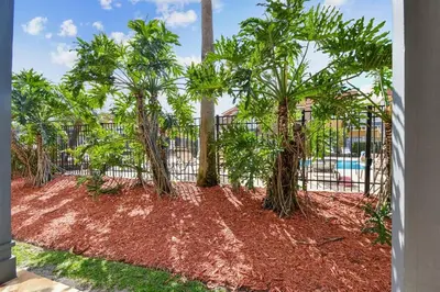 a group of trees in front of a fence at Family Stay Close to Disney Parks in Kissimmee