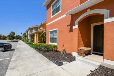 a brick building with a black door and a driveway at Disney Retreat – 15min to Parks in Kissimmee
