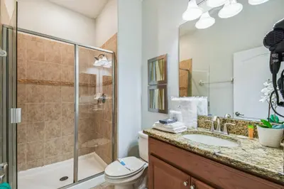 a bathroom with a shower toilet and a sink at Disney Retreat – 15min to Parks in Kissimmee