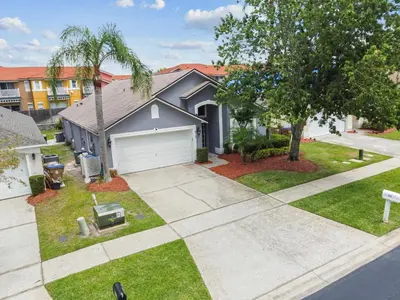 a house with a driveway and a tree at Family Retreat near Disney in Kissimmee