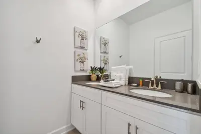 a white bathroom with a sink and a mirror at Family Retreat near Disney in Kissimmee