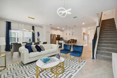 a living room with a white couch and blue chairs at Family Retreat near Disney in Kissimmee