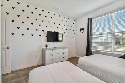 a bedroom with two beds and a tv on a wall at Spacious Orlando Stay near Disney in Kissimmee
