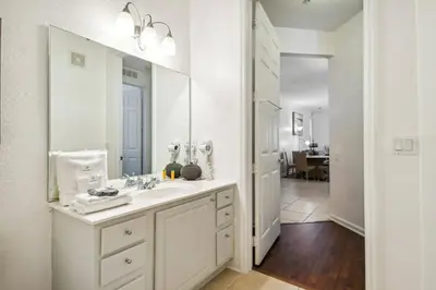 a white bathroom with a sink and a mirror at Orlando Stay Near Universal Studios in Orlando