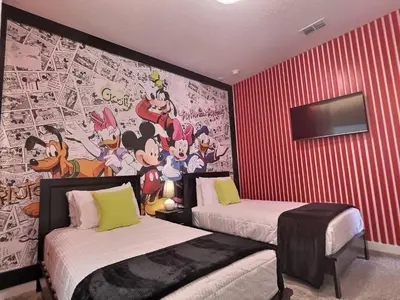 a bedroom with two beds and a mural of cartoons at Orlando Luxury Stay Near Disney Parks in Kissimmee