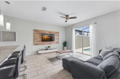 a living room with a couch and a ceiling fan at Orlando Stay Near Disney with Private Pool in Kissimmee