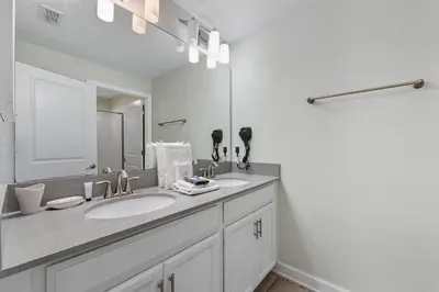 a white bathroom with two sinks and a mirror at Orlando Stay Near Disney with Private Pool in Kissimmee