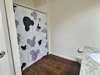 a bathroom with a shower curtain with a toilet at Family Getaway Near Disney Parks in Kissimmee