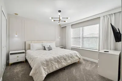 a white bedroom with a bed and a window at Disney Getaway: Private Pool Resort in Kissimmee