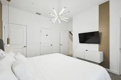a white bedroom with a white bed and a television at Private Pool Luxury Resort Amenities in Kissimmee