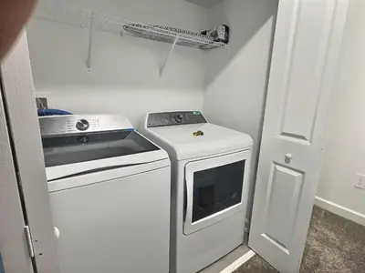 a small kitchen with a stove and a washer at Luxury Home Near Disney Orlando in Kissimmee