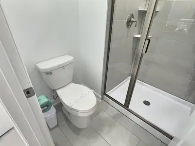 a white bathroom with a toilet and a shower at Luxury Home Near Disney Orlando in Kissimmee