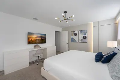 a white bedroom with a bed and a desk at Luxury Family Stay Near Disney in Kissimmee