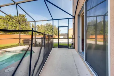 an external view of a glass house with a swimming pool at Family Townhome w Private Pool Orlando in Kissimmee