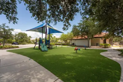 a playground with a swing set in a park at Family Townhome w Private Pool Orlando in Kissimmee
