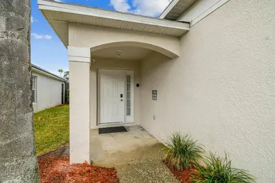 a white house with a white door and a porch at 4BR Home Game Room in Lake Berkley in Kissimmee