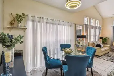 a living room with a glass table and blue chairs at Resort Townhome · Sleeps 8 · Pool in Kissimmee