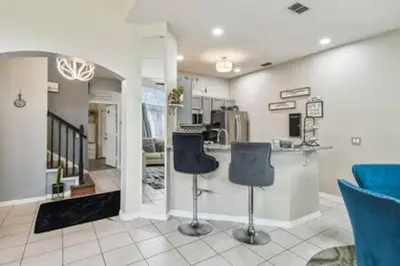 a living room with two chairs and a counter at Resort Townhome · Sleeps 8 · Pool in Kissimmee