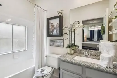 a bathroom with a sink and a toilet and a mirror at Resort Townhome · Sleeps 8 · Pool in Kissimmee