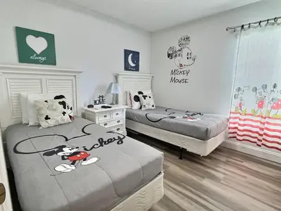 a bedroom with two beds with mickey mouse on them at Lake Berkley · Family Home Near Disney in Kissimmee