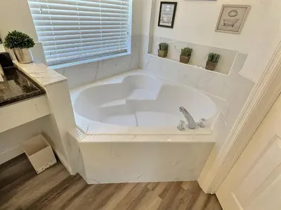 a white bath tub in a bathroom with a window at Lake Berkley · Family Home Near Disney in Kissimmee