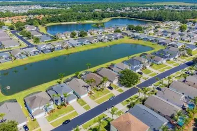 an aerial view of a suburb with houses and a lake at Lake Berkley · Family Home Near Disney in Kissimmee