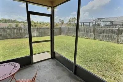 a screened in porch with a view of a yard at Montego Bay Retreat w Pool in Kissimmee